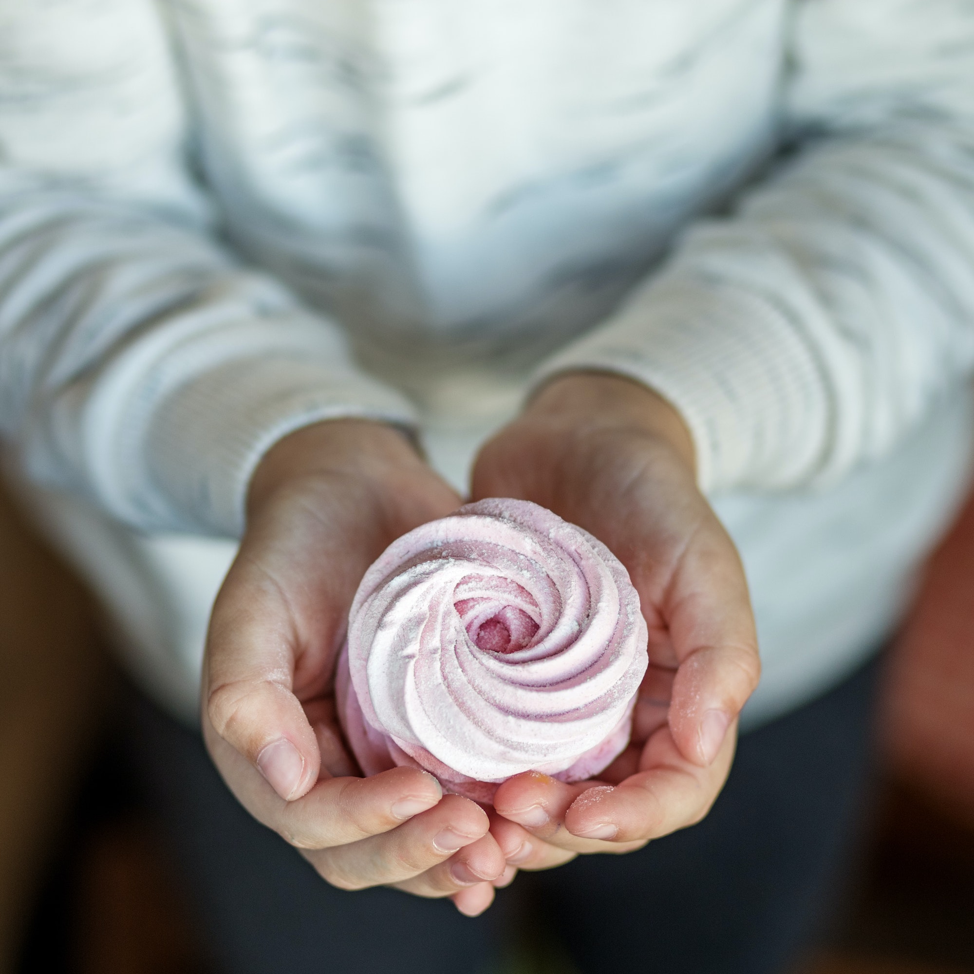 Delicate sweet marshmallows in children's hands. The concept of food and sweets
