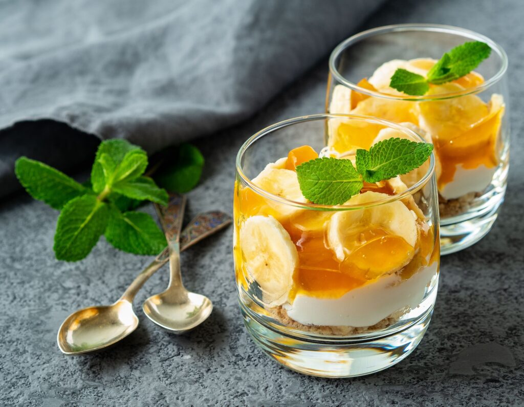 Healthy layered dessert with yogurt, banana, mango jam