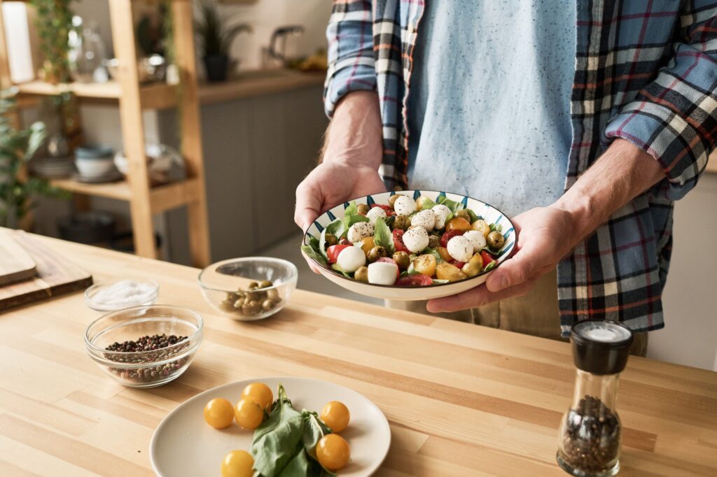 Man preparing vegetable salad for dinner