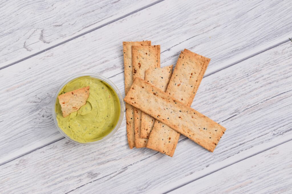 round pot of guacamole dip and rectangle crackers